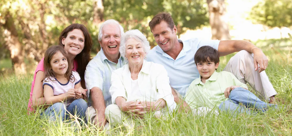 Portrait Of Extended Family Group Sitting In Park